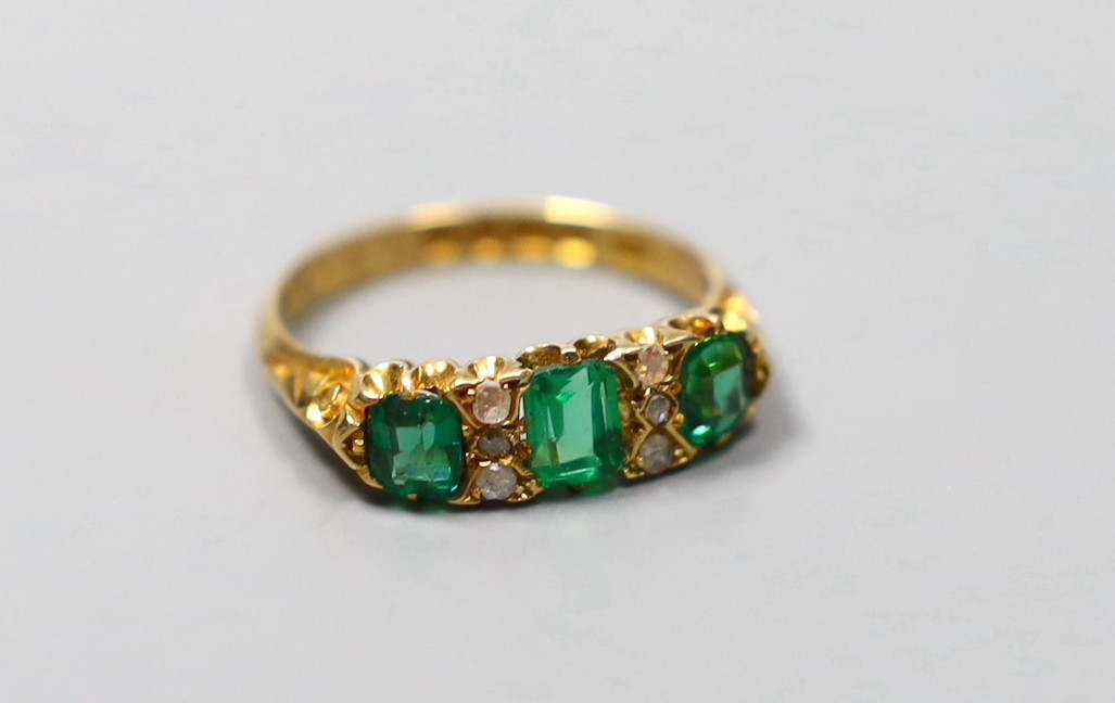 An Edwardian 18ct gold, thee stone green doublet and rose cut diamond chip set half hoop ring, size O, gross 4 grams.